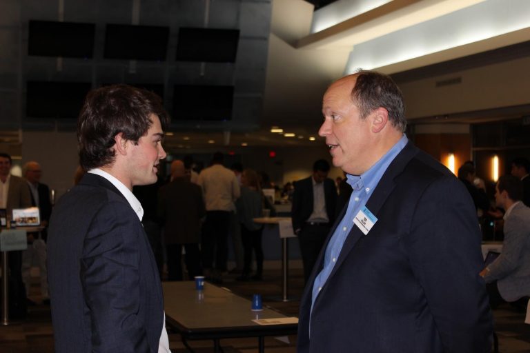 Ted Zoller (right), T.W. Lewis Clinical Professor of Strategy and Entrepreneurship and Director of the Center for Entrepreneurial Studies, converses with a pitch party judge.